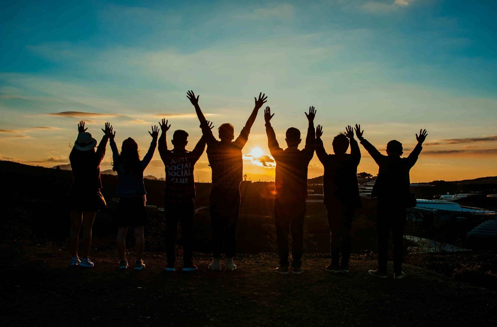 Grupo de viajeros celebrando juntos al atardecer en un viaje organizado